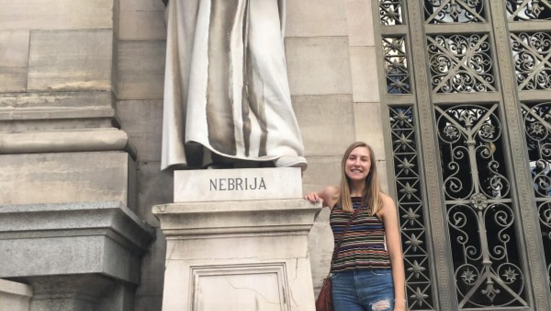 A person standing next to a statue.