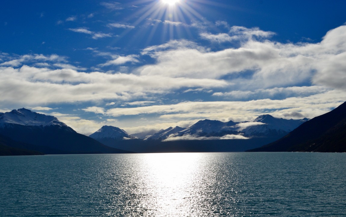 Sunny blue sky with mountains and water