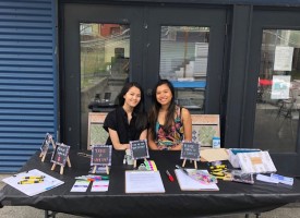 Two people sitting at an informational booth table