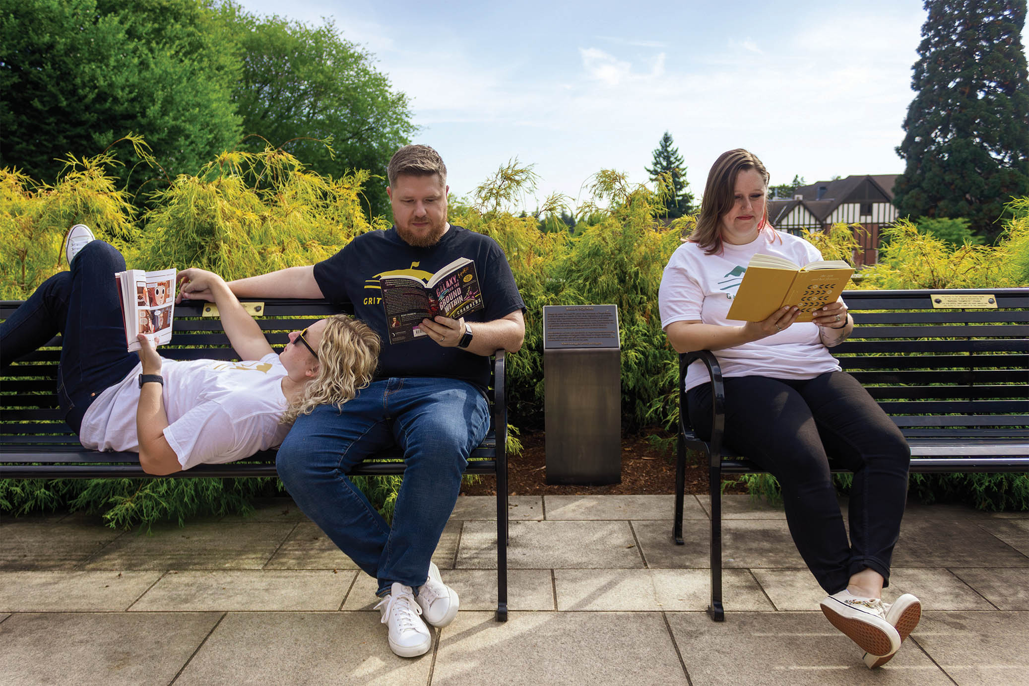 Jeff Hanway ’09, Kegan Hanway ’10, and Kaitlin Chandler ’11 reading books on benches on campus.