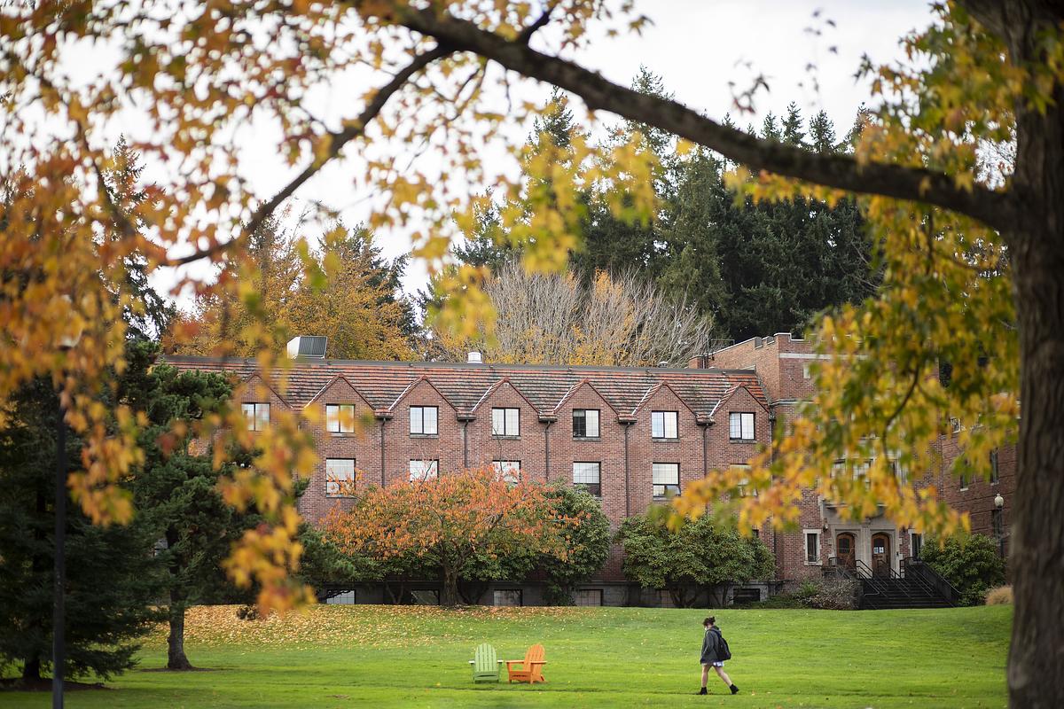 Campus boasts its fall colors. Fall leaves with red brick building in the background.