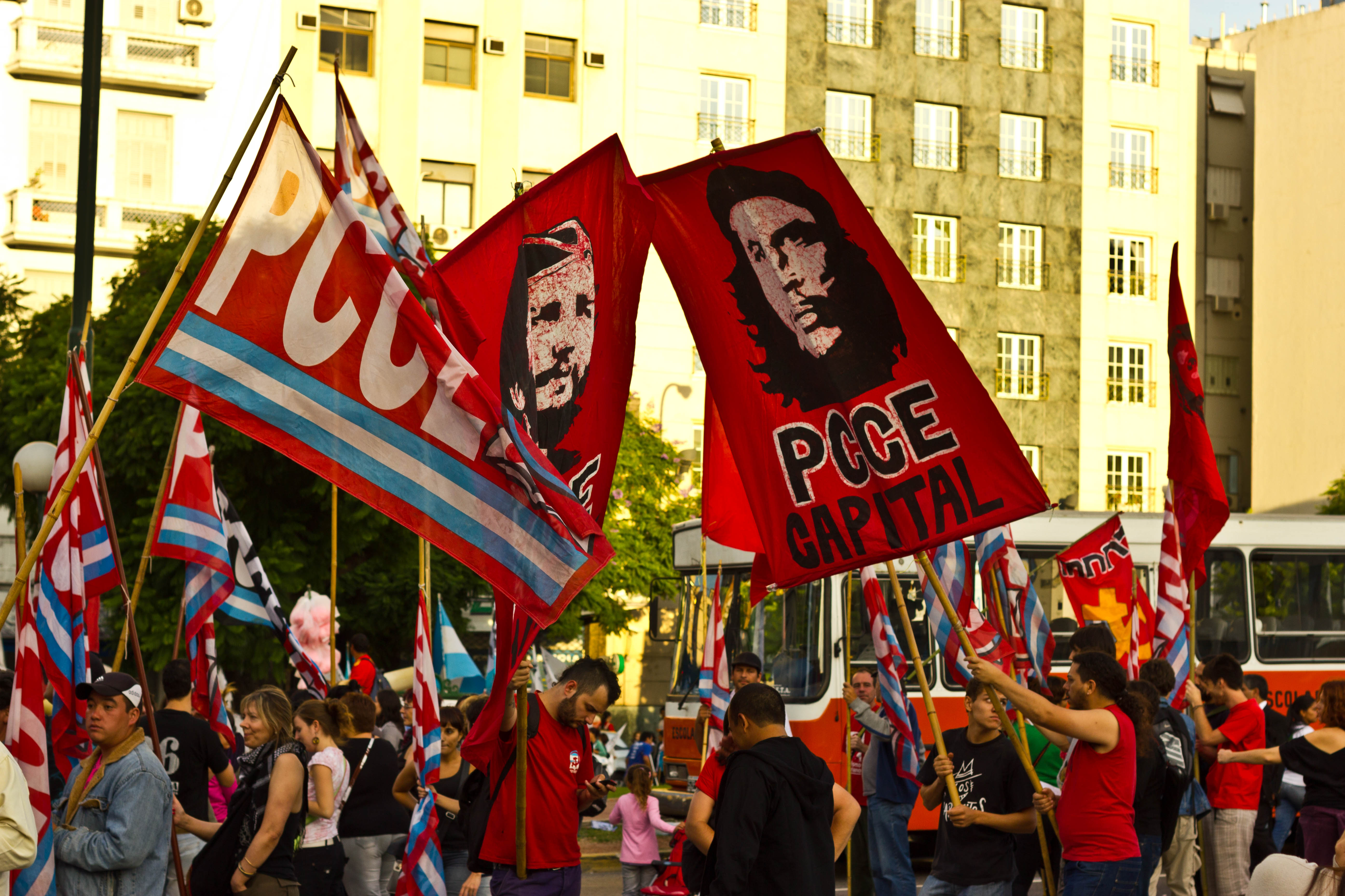 Protestors carrying flags bearing the image of Che Guevara