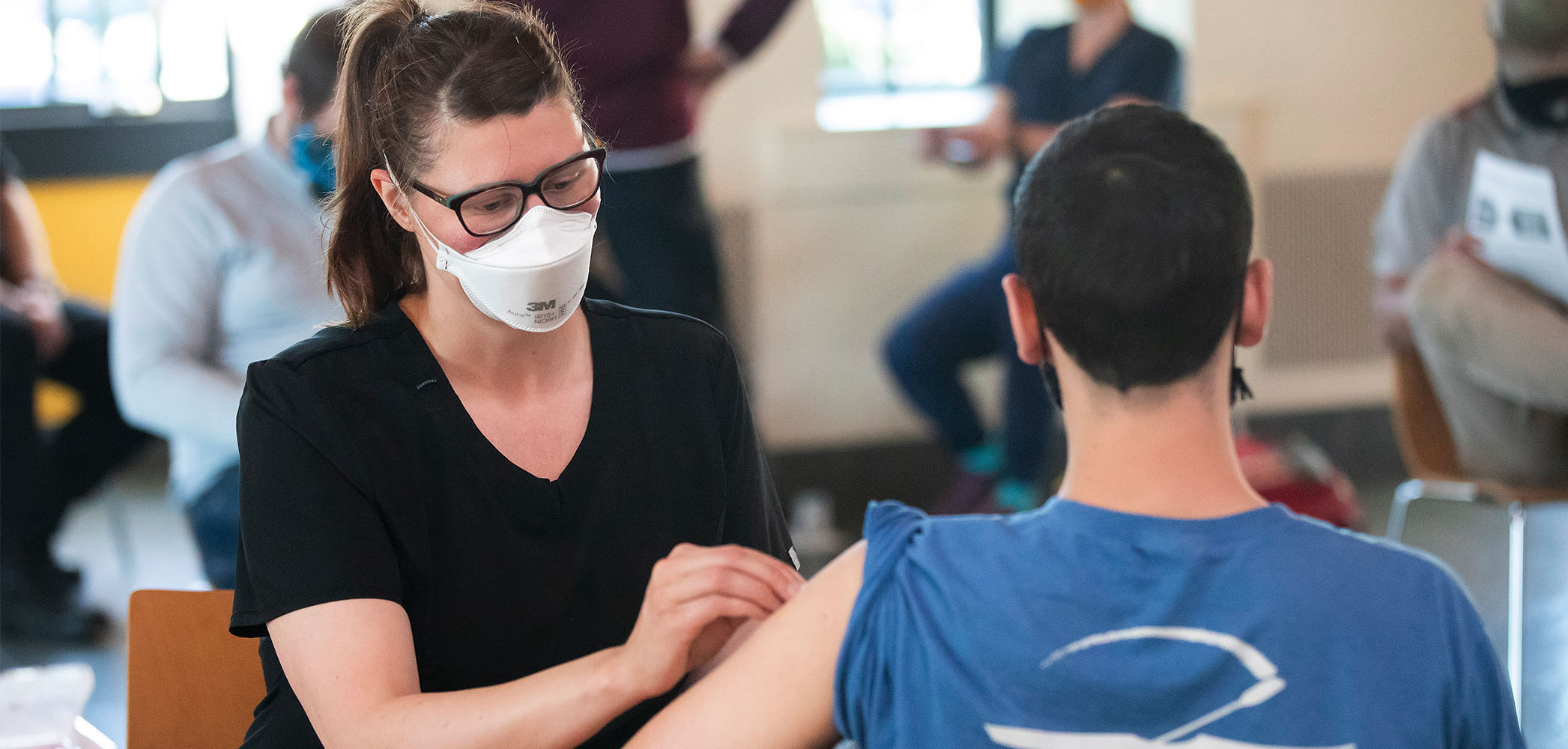 A shot clinic on campus where a student receives a vaccination.