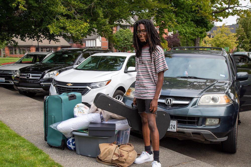 A student on move-in day with his pile of stuff.