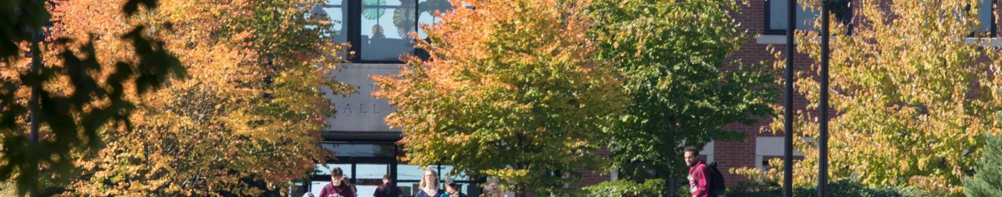 Trees and people outside Lowry Wyatt Hall during the fall season