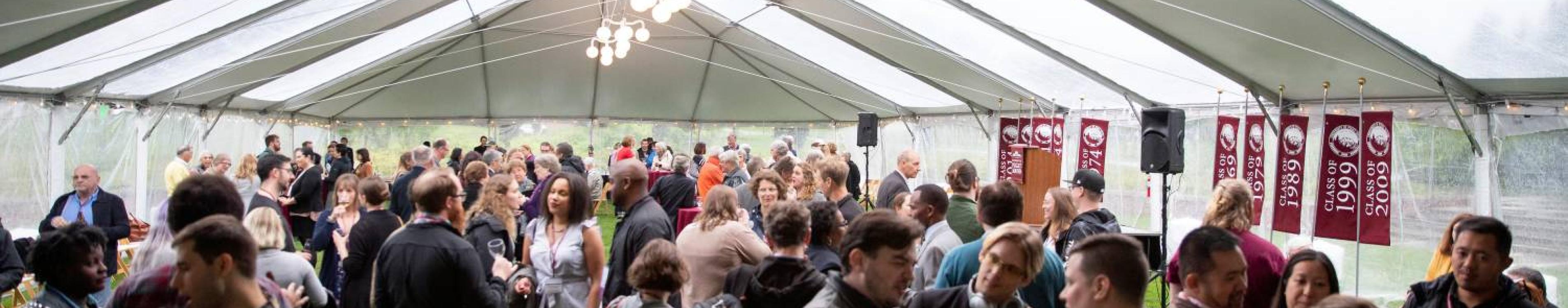 Attendees at an event in a marquee on the lawn