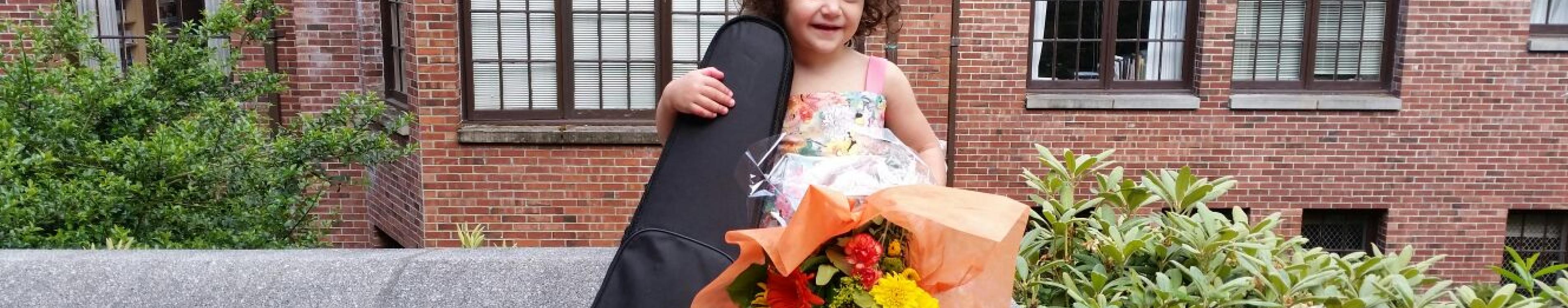 Young girl holding a flower bouquet and violin