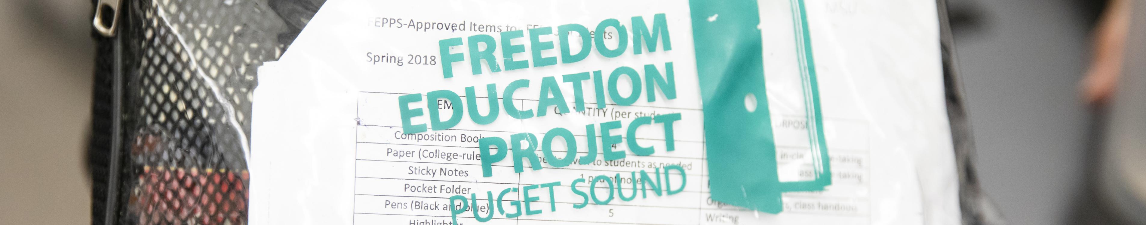 A clear bag with the words Freedom Education Project Puget Sound in green on the exterior. 