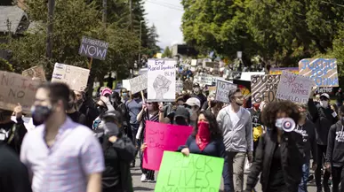 A group of protesters marching with signs