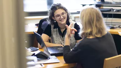 Nola Thury ’22 talking with a woman at a table