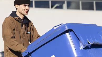 Alden Robert ’23 moves a blue recycling bin