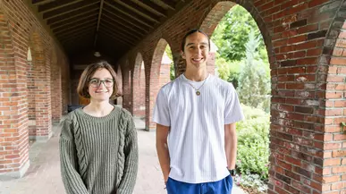 Tdohasan Chstang Sunray  and Daisy Davidson-Innis stand under red brick arches. 