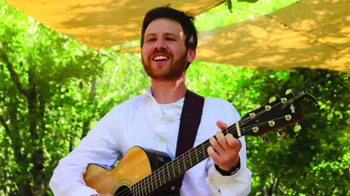 Gabriel Lehrman '16 plays the guitar while leading a summer camp.