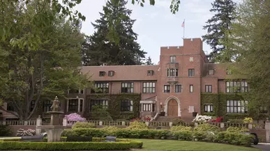 Jones Hall sits behind a flower garden on campus. 