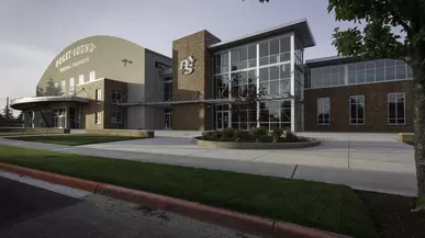 The exterior of Memorial Fieldhouse is seen with sun setting behind it. 