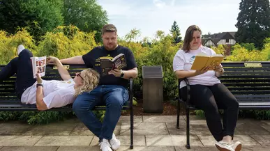 Jeff Hanway ’09, Kegan Hanway ’10, and Kaitlin Chandler ’11 reading books on benches on campus.