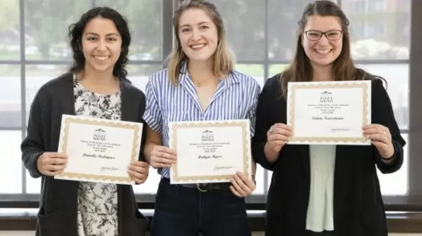 Three award recipients holding certificates