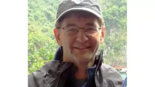 Portrait of Peter Wimberger wearing a rain jacket and a ball cap standing outside