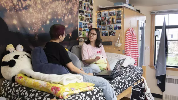 Two students hang out in a residence hall room