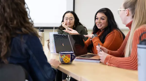 Students & teacher conversing in a classroom