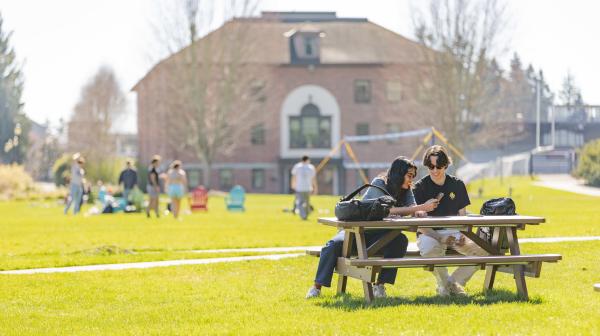 Students study together on Todd Field with Warner Gymnasium in the background.