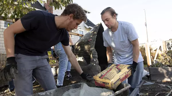 Student volunteers working with concrete