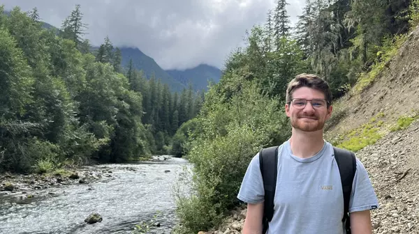 Gavin Sands standing next to a river