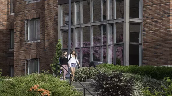 Two students walking past the floor to ceiling windows of Trimble Forum.