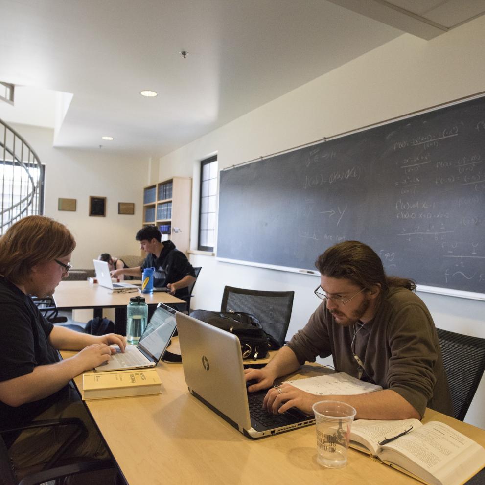 Several students work on laptops in the Mathematics Lounge in Thompson Hall.