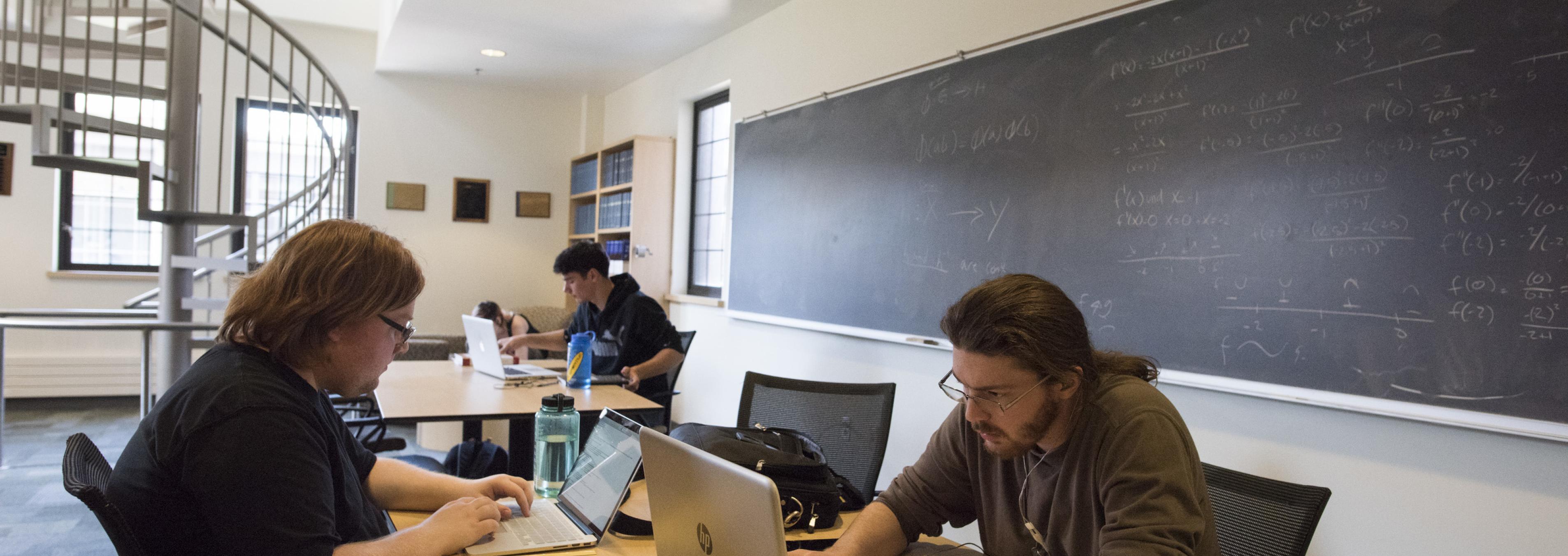 Several students work on laptops in the Mathematics Lounge in Thompson Hall.