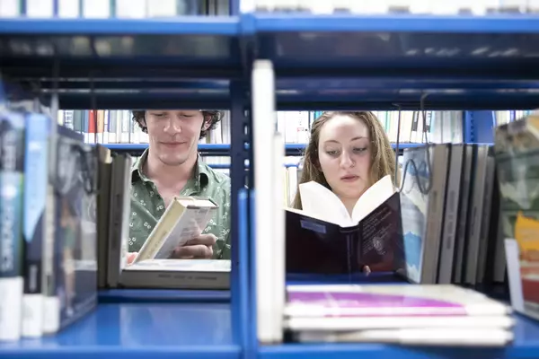 Two students selecting books from the library.