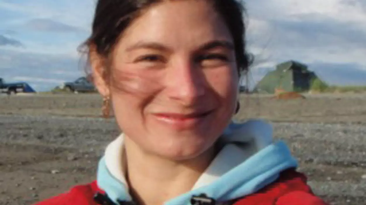 A woman in a red jacket smiling