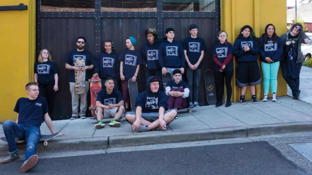 Group of students standing outside of a yellow building