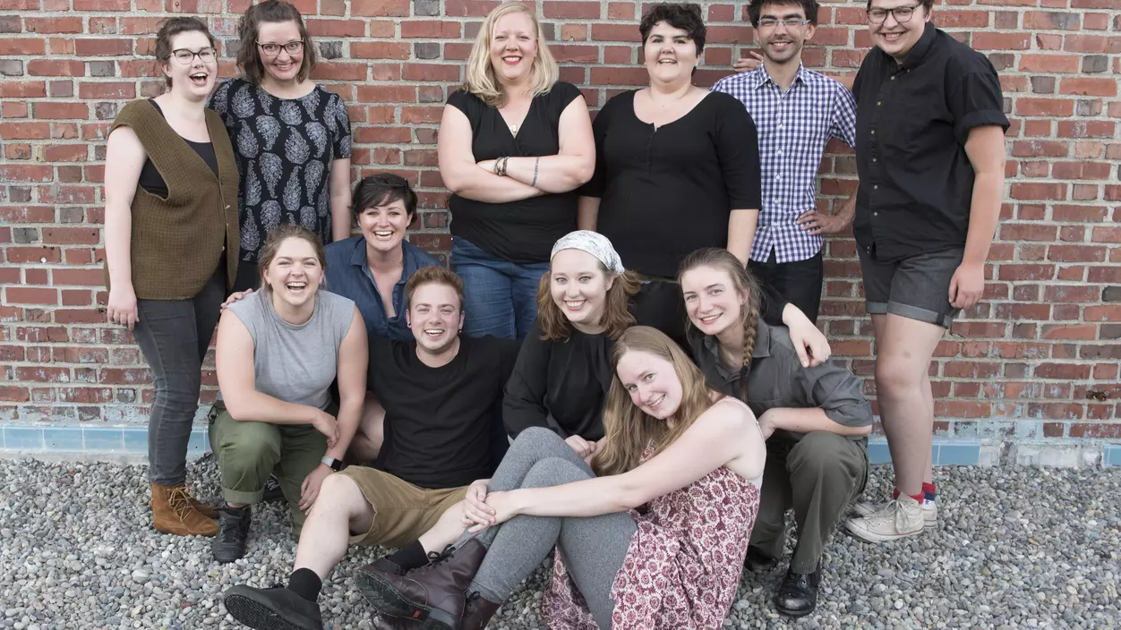 Group of people in front of a brick wall