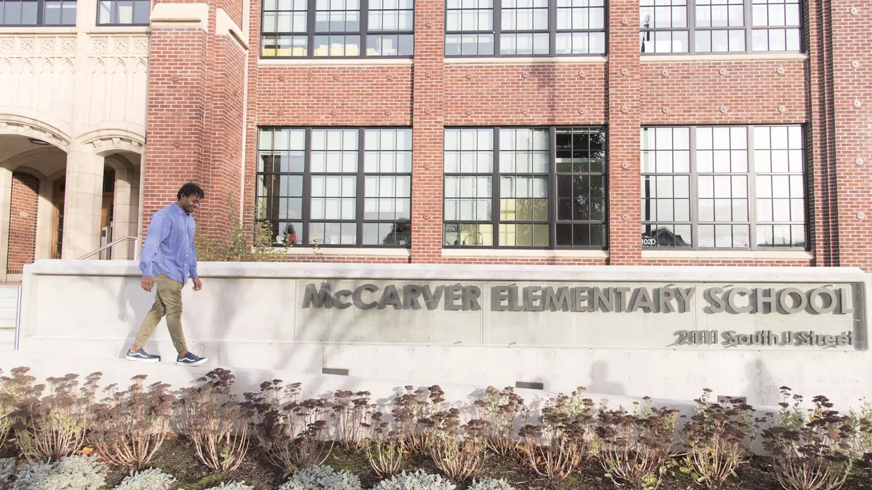 Person walking in front of the entrance to McCarver Elementary School