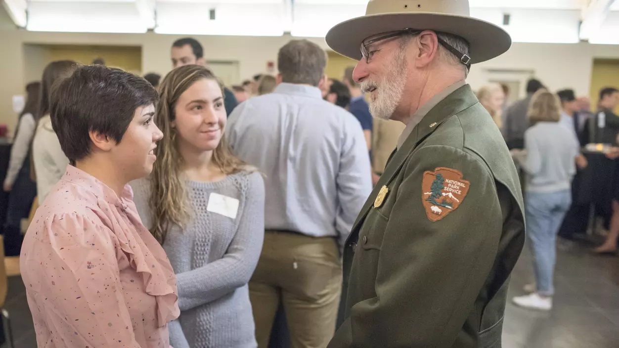 Three people talking at a networking event