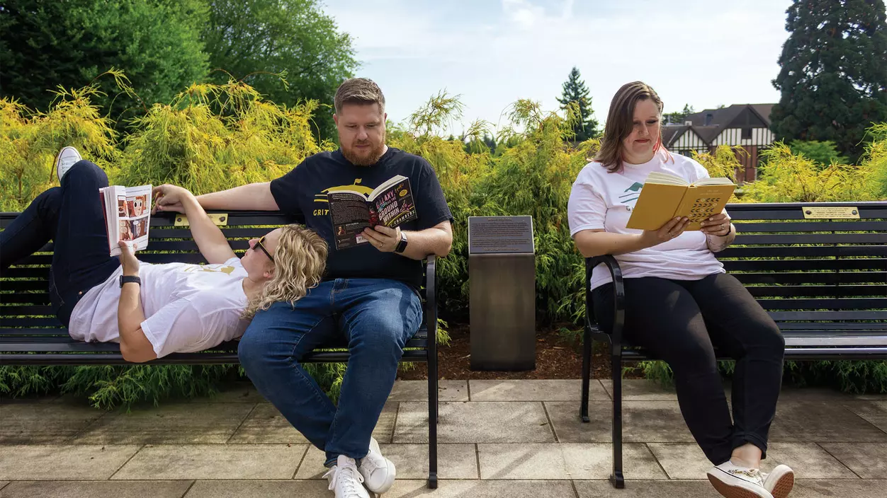 Jeff Hanway ’09, Kegan Hanway ’10, and Kaitlin Chandler ’11 reading books on benches on campus.