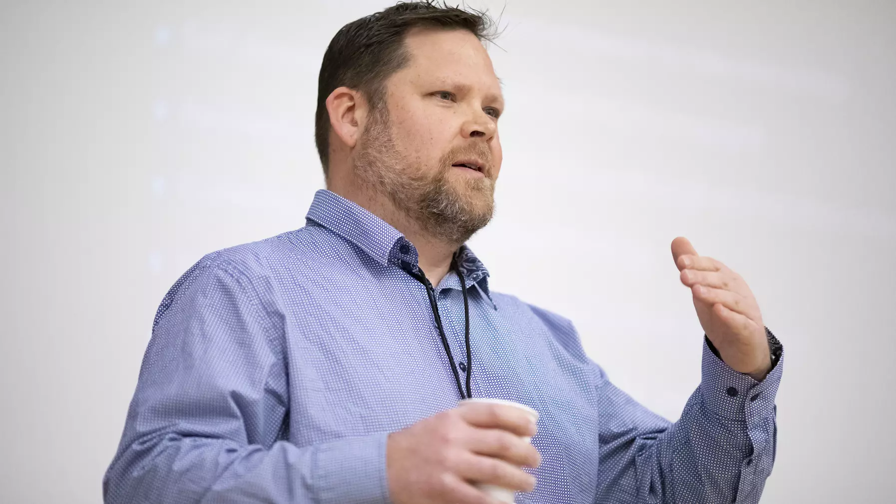 Man in a blue shirt talking