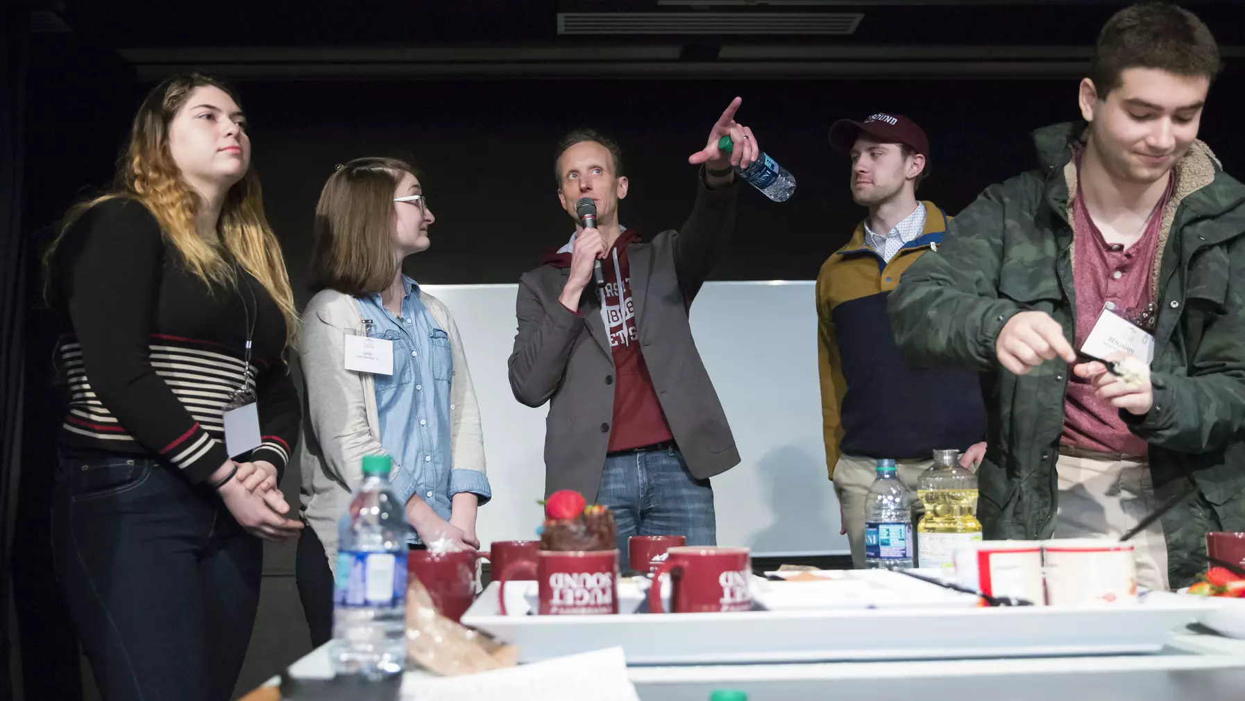 Man standing in the middle of a group of people and pointing upward