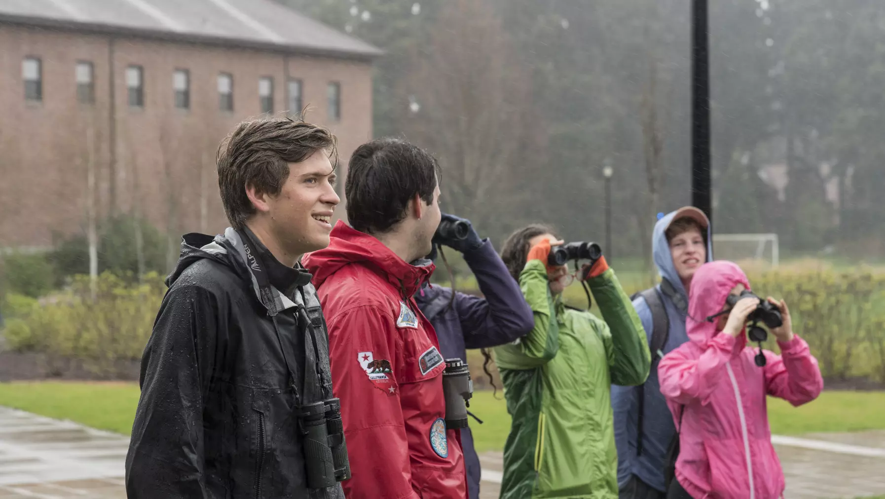 A group of people where some are using binoculars