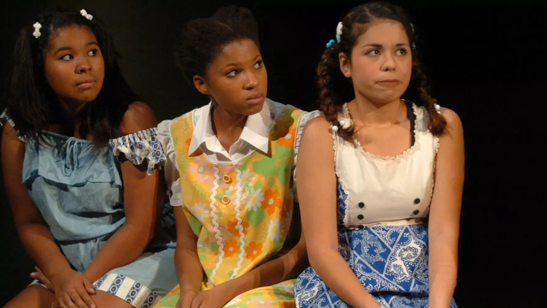 Three actresses sitting on stage