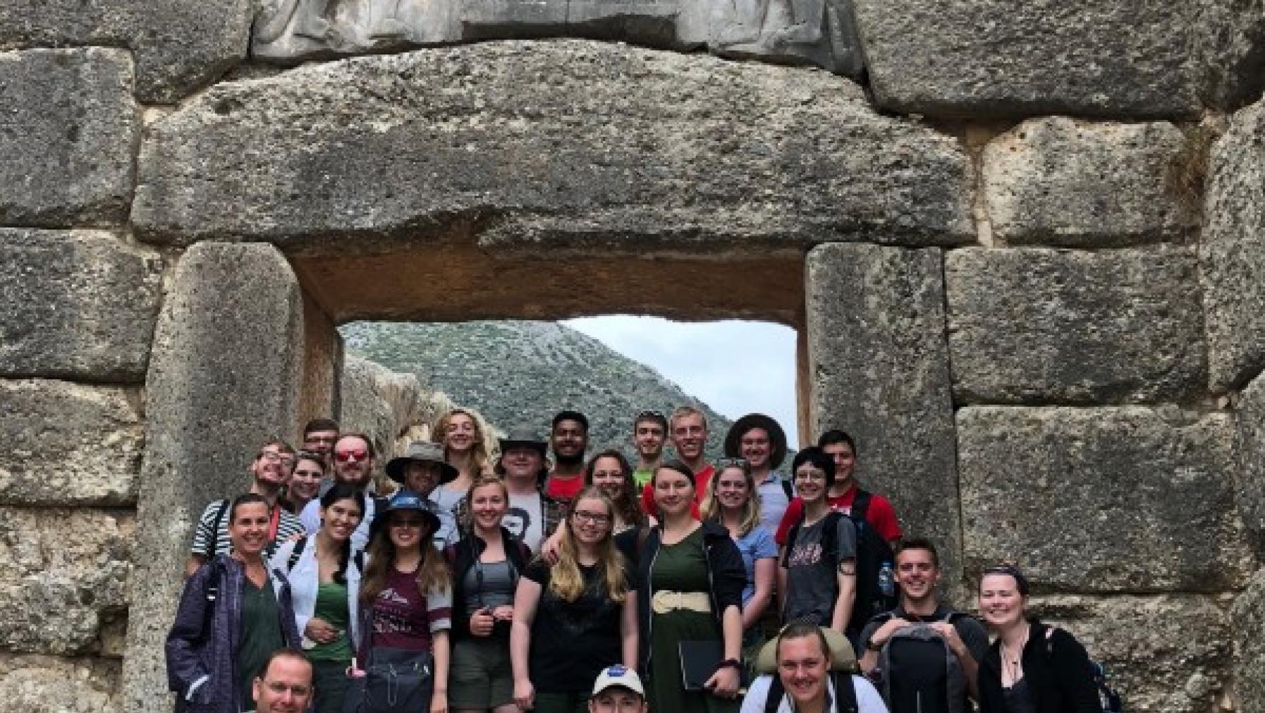 Students posing in front of Greek ruins