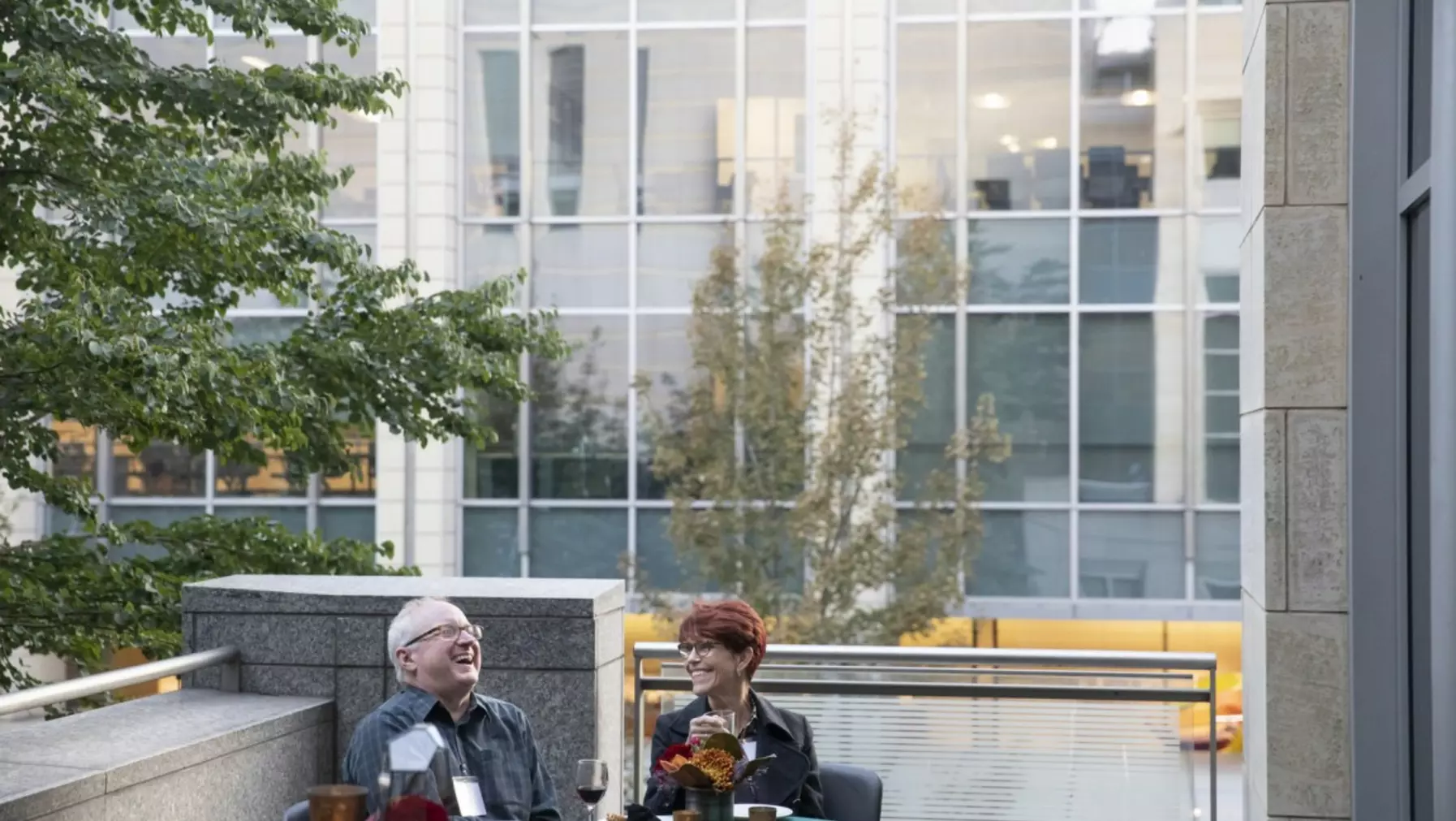 Two people enjoying themselves on an outdoor balcony