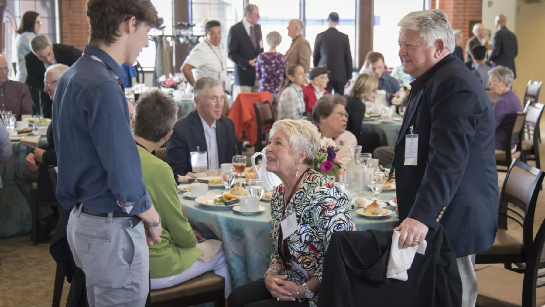 Student talking with a group of people at a table