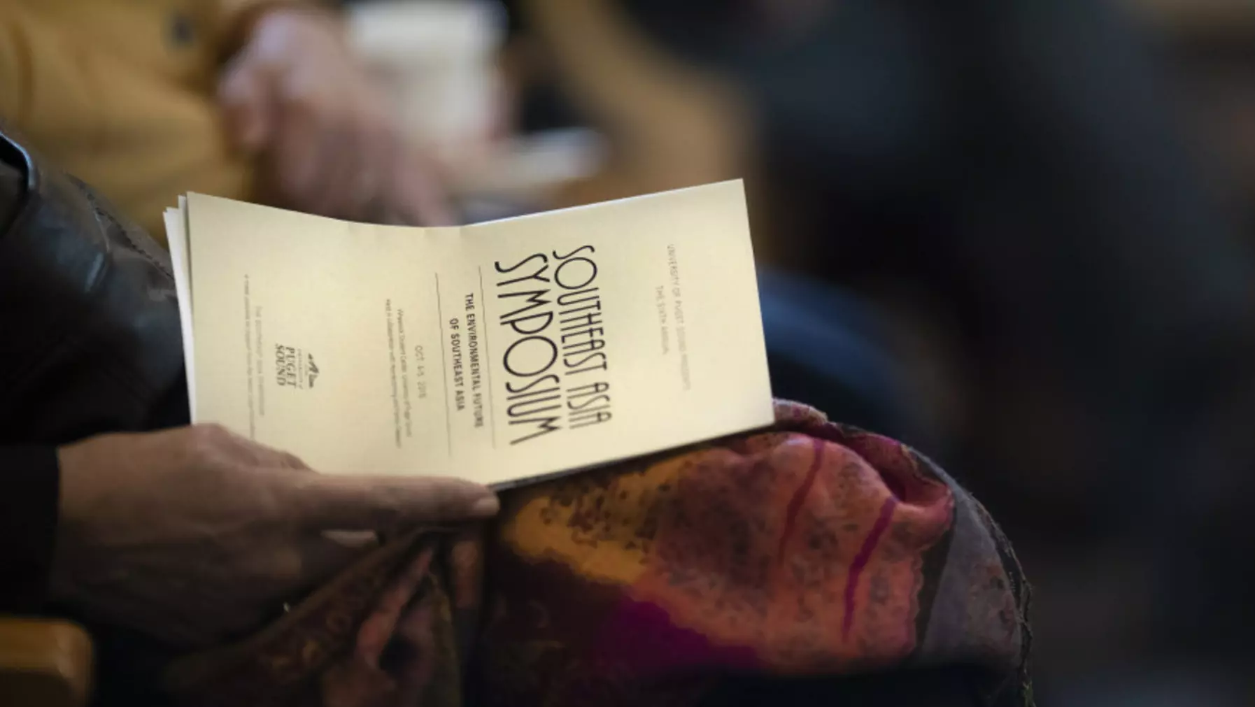 Person holding the Symposium information booklet