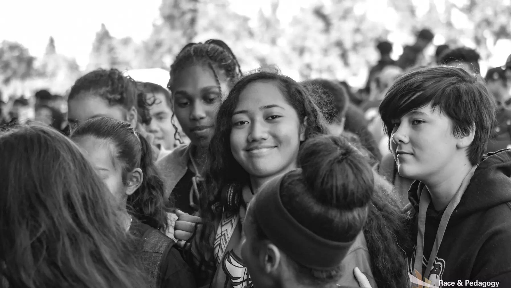 Black and white image of students entering the fieldhouse, smiling