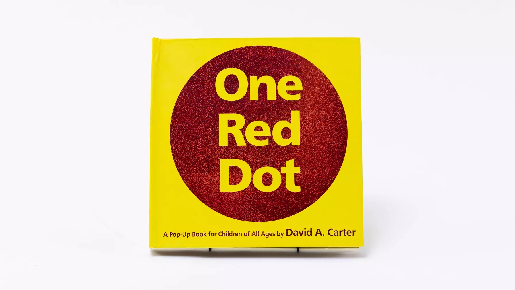 A bold red circle on yellow on the cover of One Red Dot.