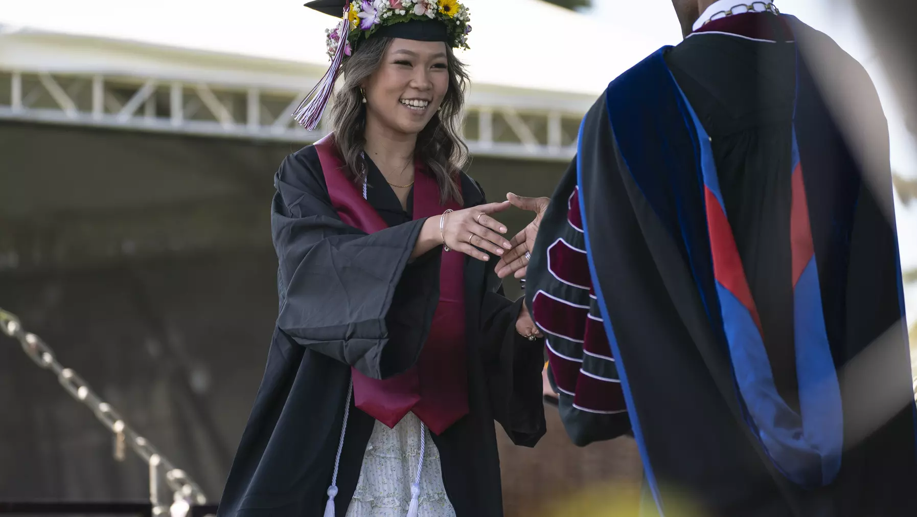 President Crawford congratulates a 2023 graduate as she receives her diploma.