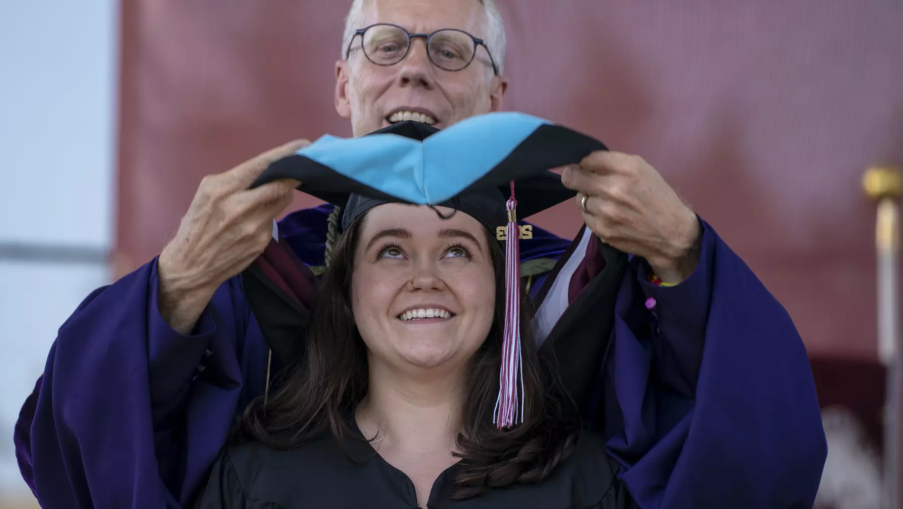 A graduate student receives her hood.