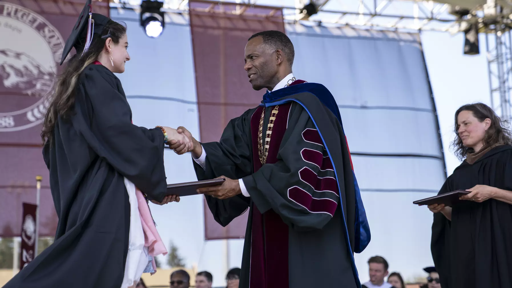 President Crawford congratulates a 2023 graduate as she receives her diploma.